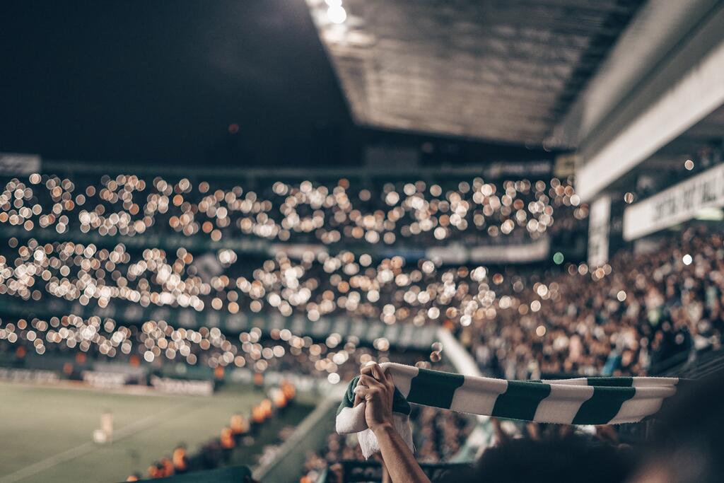 Fotbolls supportrar håller upp halsdukar på arena